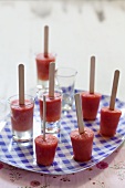 Fruit sorbet on sticks on a checked plate