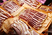 Fresh Slices of Bacon on Paper on Display at Market