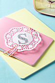 A notebook decorated with a symbol and a doily