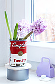 Hyacinths in a retro-style tin can in front of a window