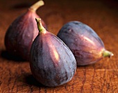 Three fresh figs on a wooden board