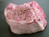 Raw Pork Chop Seasoned with Coarse Ground Pepper