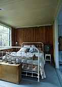 Vintage bed with white-painted metal frame in rustic bedroom