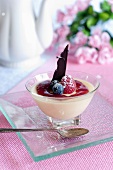 Bavarian cream with fruit sauce, a chocolate leaf and berries