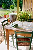 Rustikaler Tisch und Stühle auf Terrasse mit Blick in Garten