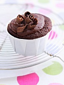 A chocolate cupcake decorated with chocolate curls