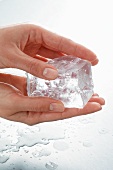 Hands holding a piece of ice
