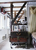 Vintage Kofferstapel auf Rollwagen in offenem Wohnraum mit alter Fachwerkkonstruktion