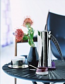 Coffee break - chrome coffee pot and vase with red flower on side table