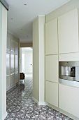 Open-plan, designer kitchen with ornamental, patterned tiled floor