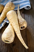 Parsnips and a tea towel on a wooden surface