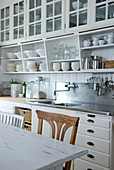 Küchenzeile mit weißen Hängeschränken, offenen Regalen und Unterschränken im Landhausstil