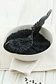 Black lentils in a bowl with a spoon