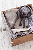 Schublade mit grauen Textilien und altem Schlüsselbund