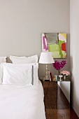 Bedroom with white bed linen and mirrored bedside table