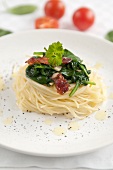 Noodle nest with spinach, dried tomatoes, bacon and parsley