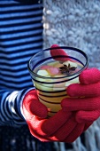 Person holding a glass of apple punch