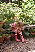 Kleines Mädchen sitze auf Holzbank im Garten