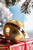 Gold Christmas tree ball ornament on a present