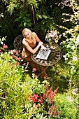 Frau mit Laptop im Garten