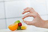 A hand holding a vitamin tablet