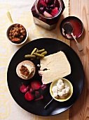 An antipasti plater of cheese, chutneys and pickles