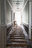 Animal-skin rugs laid out on wooden floor in narrow hallway