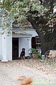 Autumnal garden in front of traditional house with dog under porch roof