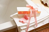 A heart-shaped bar of soap in a gift box tied with a silk ribbon