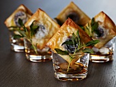 An aperitif accompanied by black pudding canapes and crispy sage