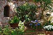 Rusty garden bench and garden table in front of brick wall