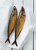 Two smoked mackerel on a piece of paper