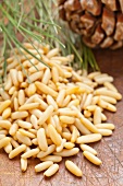 A pile of pine nuts with a pine cone in the background