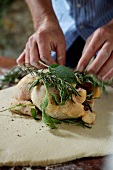 Stuffing a chicken with herbs