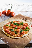 A pizza topped with cherry tomatoes and basil
