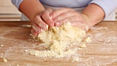 Pastry ingredients being kneaded by hand