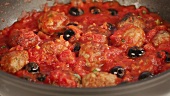 Meat balls simmering in tomato sauce