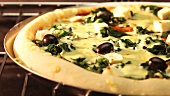 A spinach, sheep's cheese and olive pizza in an oven (time lapse)