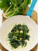 Creamed Spinach with Garlic Cloves in a Skillet; From Above; Fresh Spinach