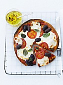 Pizza mit Mozzarella, Tomaten und Oliven, angeschnitten