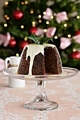A sliced Christmas pudding topped with cream
