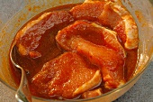 Raw Boneless Pork Chops Soaking in Marinade