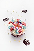 A cupcake topped with butter cream and a Union Jack surrounded with chocolate crowns