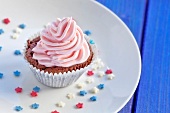 A chocolate cupcakes decorated with pink cream