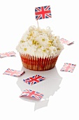 A cupcake decorated with golden beads and a Union Jack