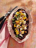 Mango and pear salad on a bed of beetroot carpaccio