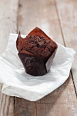 A chocolate muffin on a piece of baking paper