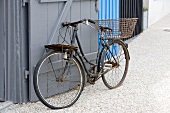 Rostiges Vintage Fahrrad an Holztor lehnend