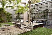 Seating area on terrace with wooden decking and butterfly chair in urban garden