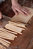 Pasta dough being cut into strips
